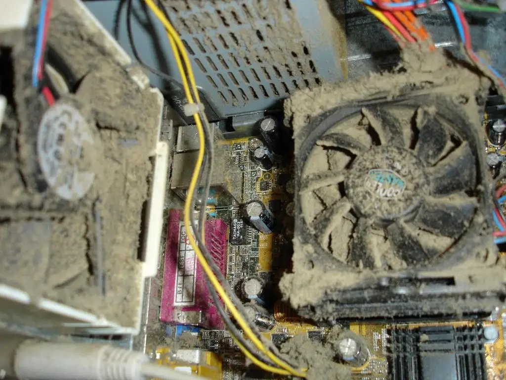 Desktop computer clogged with heavy dust on the CPU fan and power supply before cleaning